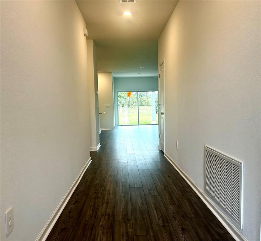 1103 Northwest 44th Court Road Ocala, FL 34482 - Photo 6 of 36 a view of a hallway with wooden floor
