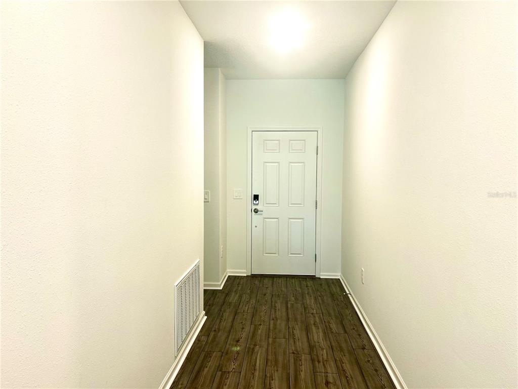 1103 Northwest 44th Court Road Ocala, FL 34482 - Photo 7 of 36 a view of a hallway with wooden floor