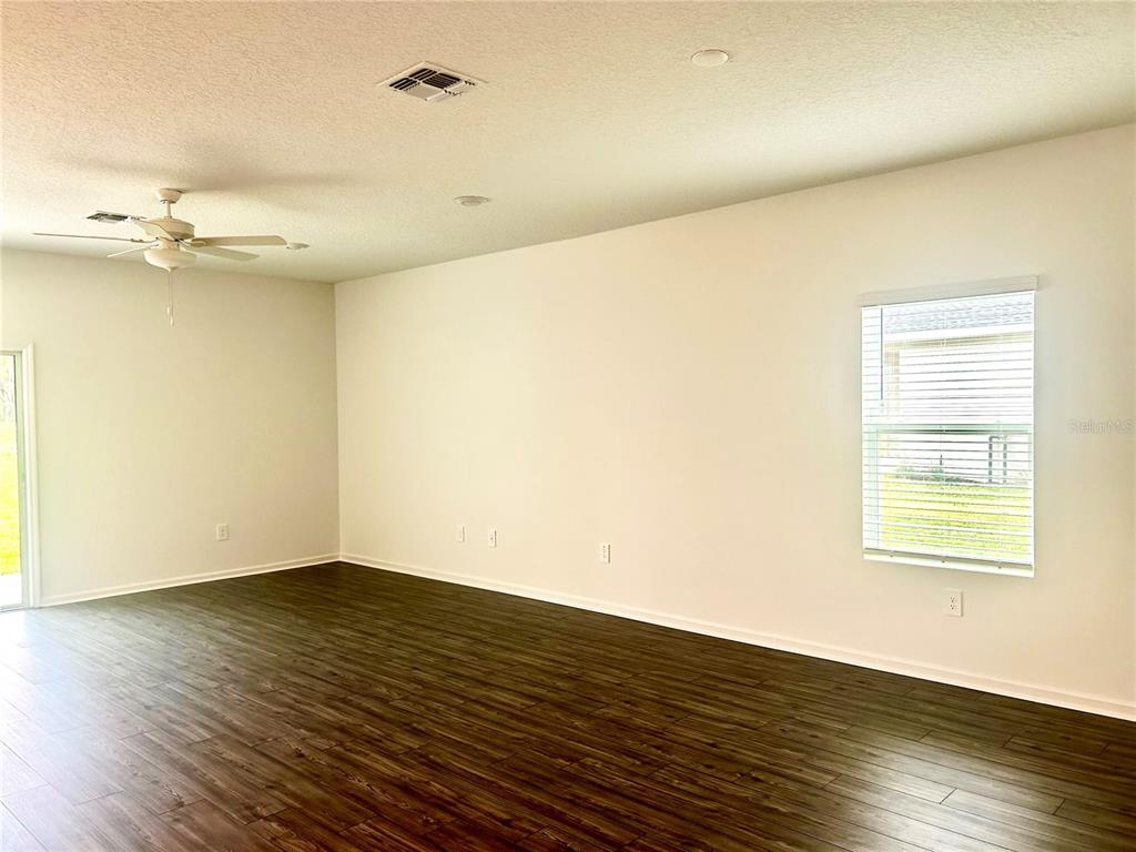 1103 Northwest 44th Court Road Ocala, FL 34482 - Photo 9 of 36 an empty room with wooden floor and windows