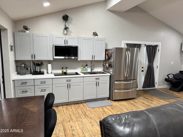 a kitchen with a refrigerator stove and white cabinets