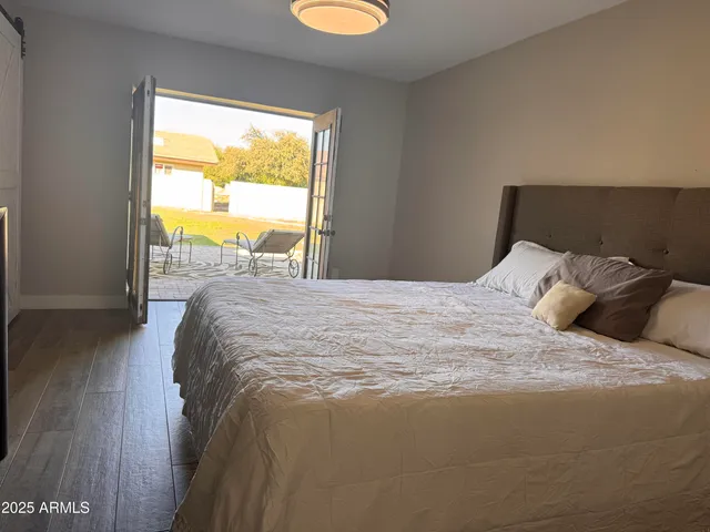 a large bed sitting in a bedroom next to a window
