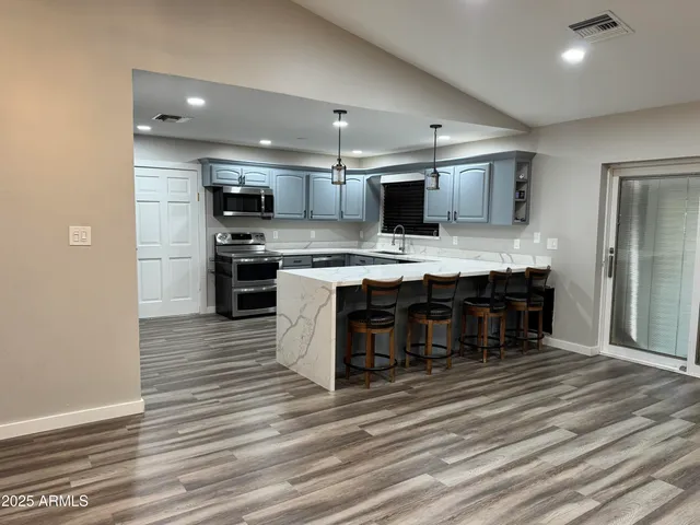a kitchen with stainless steel appliances a refrigerator and a stove top oven