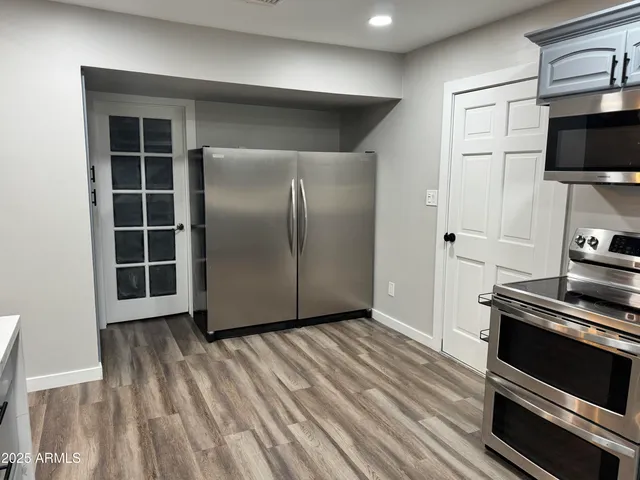 a view of kitchen with wooden floor and electronic appliances