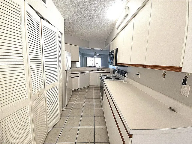 a kitchen with white cabinets and white appliances