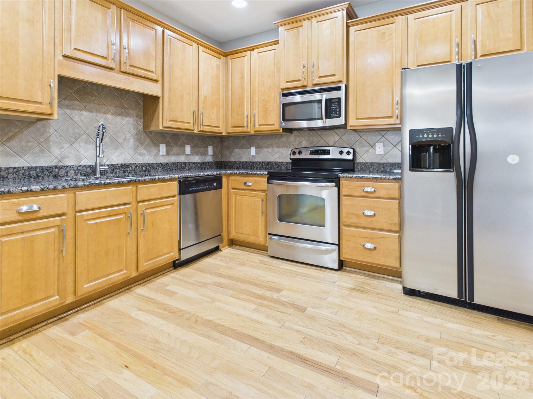 5690 Stafford Road Charlotte, NC 28215 - Photo 5 of 25 a kitchen with stainless steel appliances granite countertop a stove a sink and a microwave