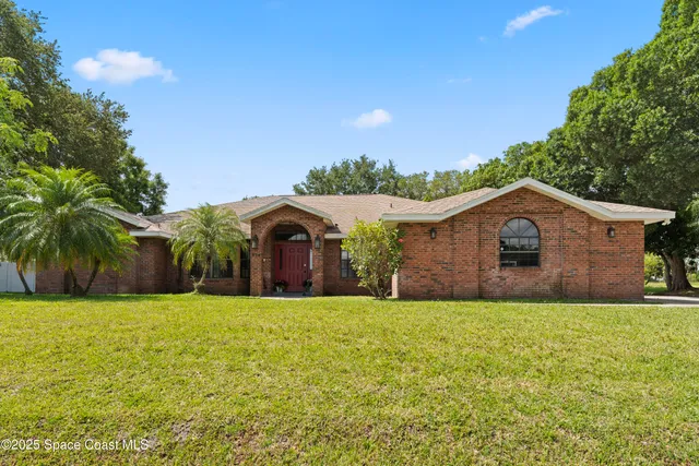 a large house with a big yard and large trees