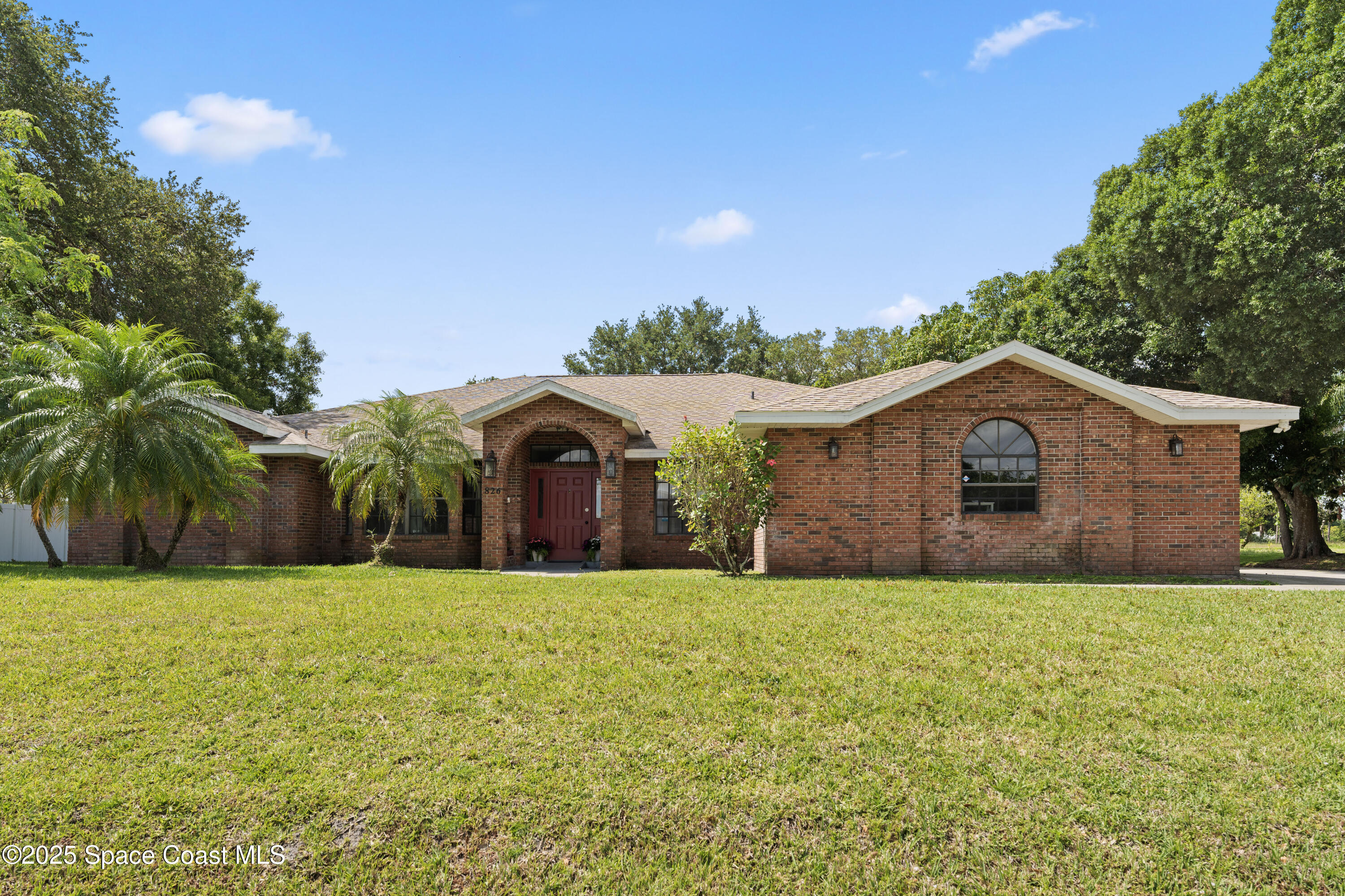 a large house with a big yard and large trees