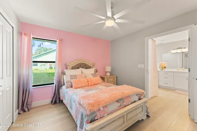 a bedroom with a bed a chandelier and a window