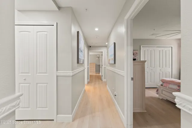 a view of a hallway with furniture and wooden floor