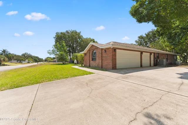 a view of a house with a yard and potted plants
