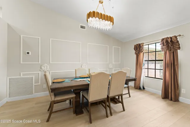 a view of a dining room with furniture and a chandelier