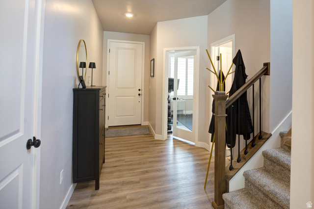 983 South 950 West Provo, UT 84601 - Photo 23 of 56 Entryway featuring wood-finish flooring, a white paneled entry door, and a staircase with wood newel post and balusters