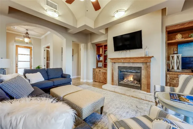 a living room with couches a fireplace and a flat screen tv