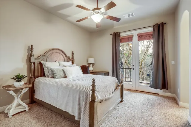 a bedroom with a large bed and a chandelier fan