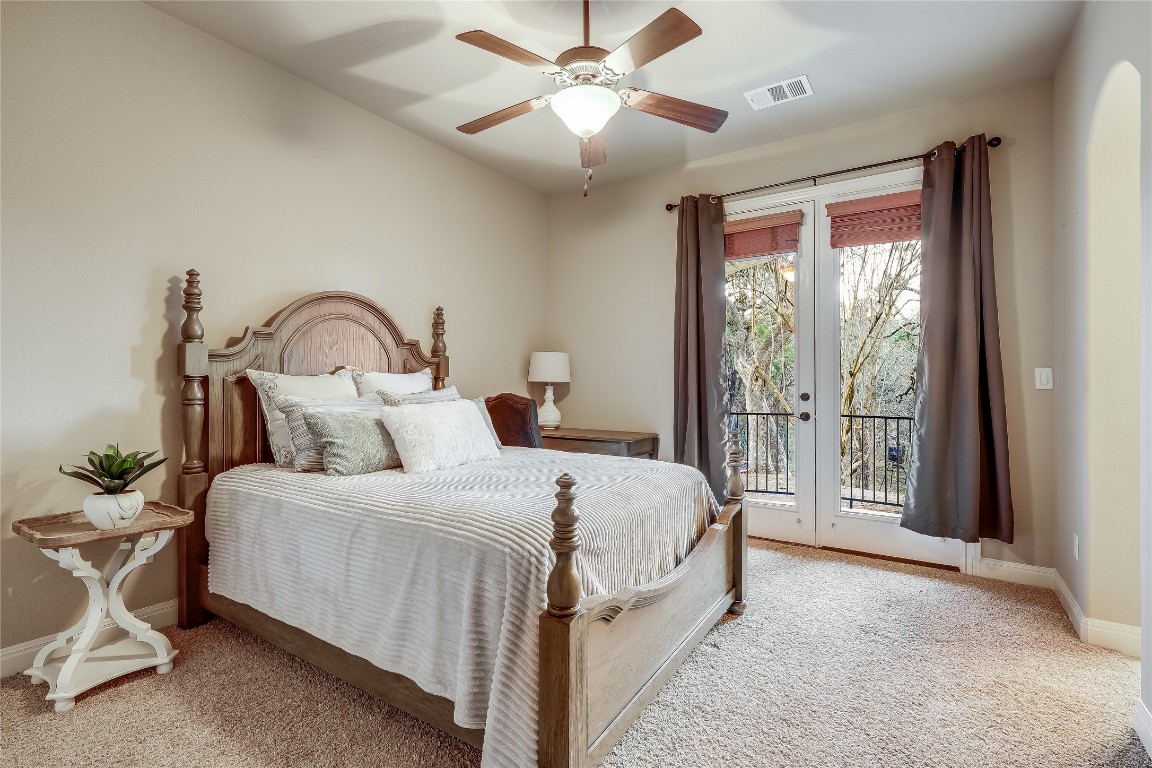 17704 Regatta View Drive Jonestown, TX 78645 - Photo 27 of 38 a bedroom with a large bed and a chandelier fan