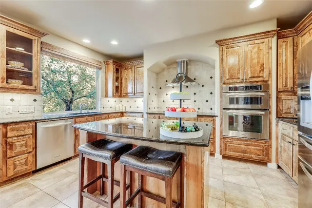 a kitchen with stainless steel appliances kitchen island granite countertop a sink and cabinets