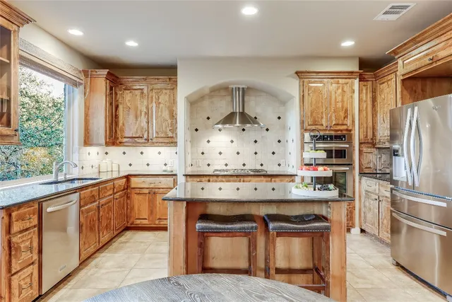 a kitchen with stainless steel appliances granite countertop a sink stove and refrigerator