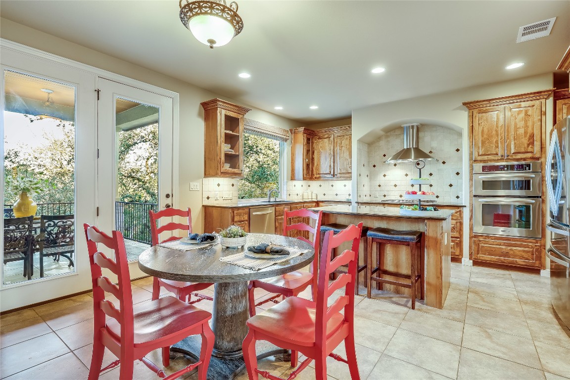 17704 Regatta View Drive Jonestown, TX 78645 - Photo 7 of 38 a kitchen with a dining table chairs and refrigerator