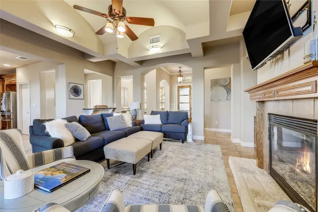 a living room with furniture a chandelier and a fireplace