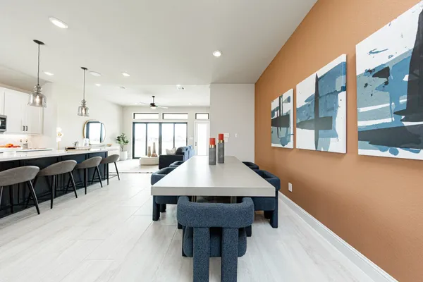 a large dining hall with stainless steel appliances kitchen island a table chairs and a sink