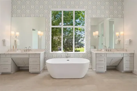 a spacious bathroom with a double vanity sink mirror and bathtub