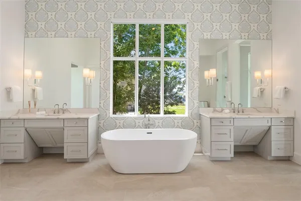 a spacious bathroom with a double vanity sink mirror and bathtub