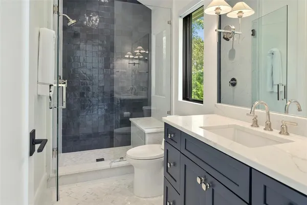 a bathroom with a sink a toilet and shower