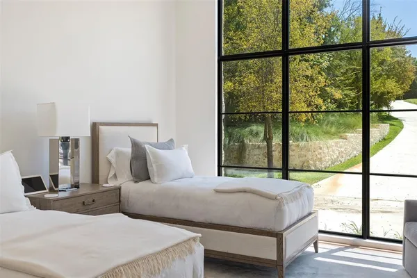 a bedroom with large window and a bed