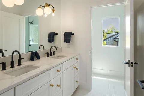 a bathroom with a double vanity sink and a mirror