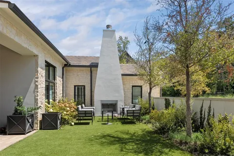 a front view of a house with a garden and sitting area