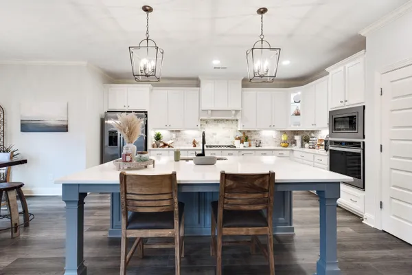 a kitchen with refrigerator a sink and chairs