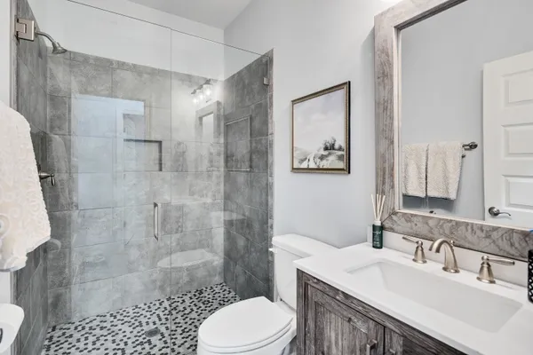 a bathroom with a sink toilet a mirror and shower