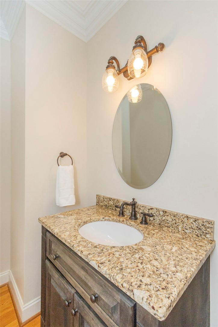 316 Avenue Of Oaks Anderson, SC 29621 - Photo 16 of 50 This bathroom features a sophisticated vanity with granite counters and a stylish oval mirror.