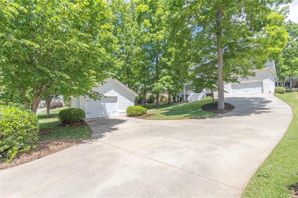 316 Avenue Of Oaks Anderson, SC 29621 - Photo 46 of 50 This spacious property features a long driveway leading to multiple garages, set against a backdrop of lush trees.