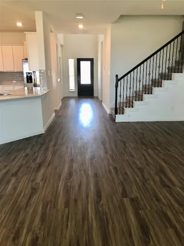 a view of a kitchen with wooden floor and windows