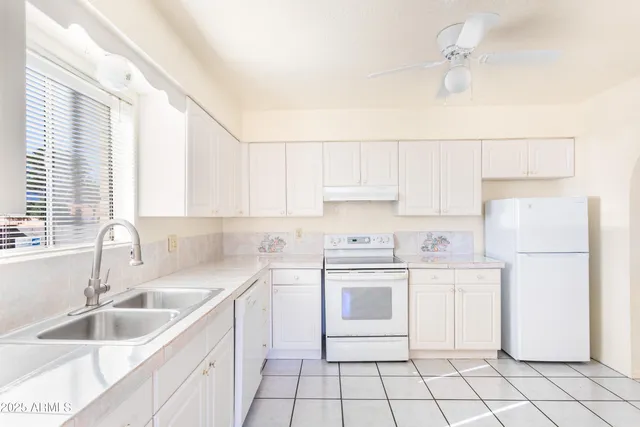a kitchen with cabinets appliances a sink and a counter top