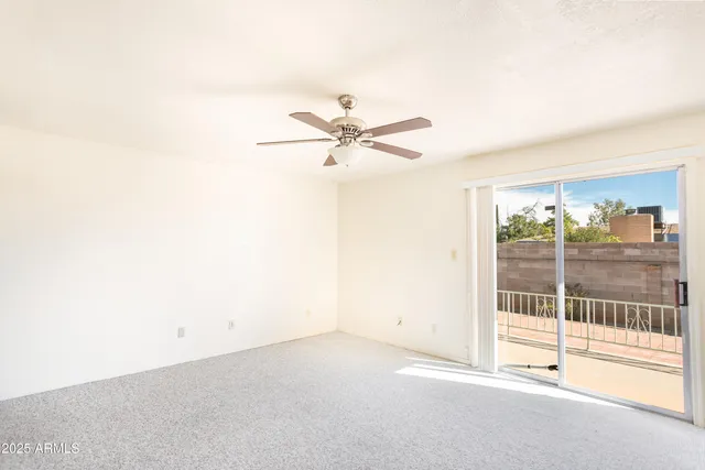an empty room with fireplace and fan