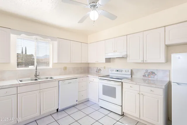 a kitchen with white cabinets sink and white appliances