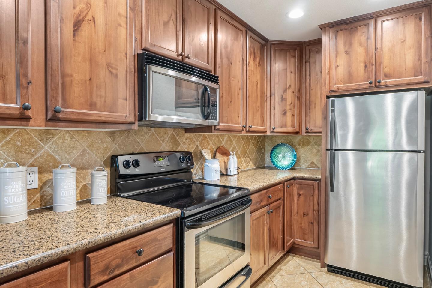 2580 Homestead Road, Unit 5201 Santa Clara, CA 95051 - Photo 10 of 38 a kitchen with granite countertop stainless steel appliances and wooden cabinets