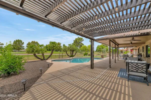 a patio with lawn chairs and wooden fence