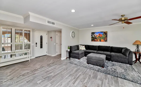 a living room with furniture ceiling fan and a window