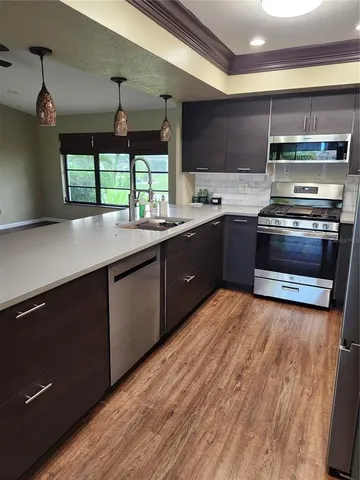 a kitchen with stainless steel appliances kitchen island granite countertop a stove a sink and a microwave