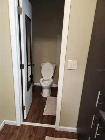 a bathroom with a toilet and a mirror