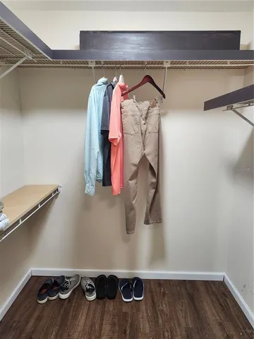 a view of walk in closet with clothes and shoes