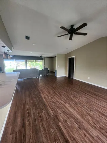 a view of empty room with wooden floor and window