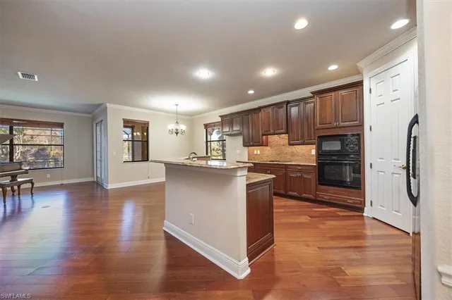 a kitchen with stainless steel appliances granite countertop a refrigerator and a stove top oven