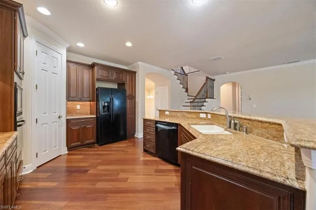 a kitchen with stainless steel appliances granite countertop a sink and a refrigerator