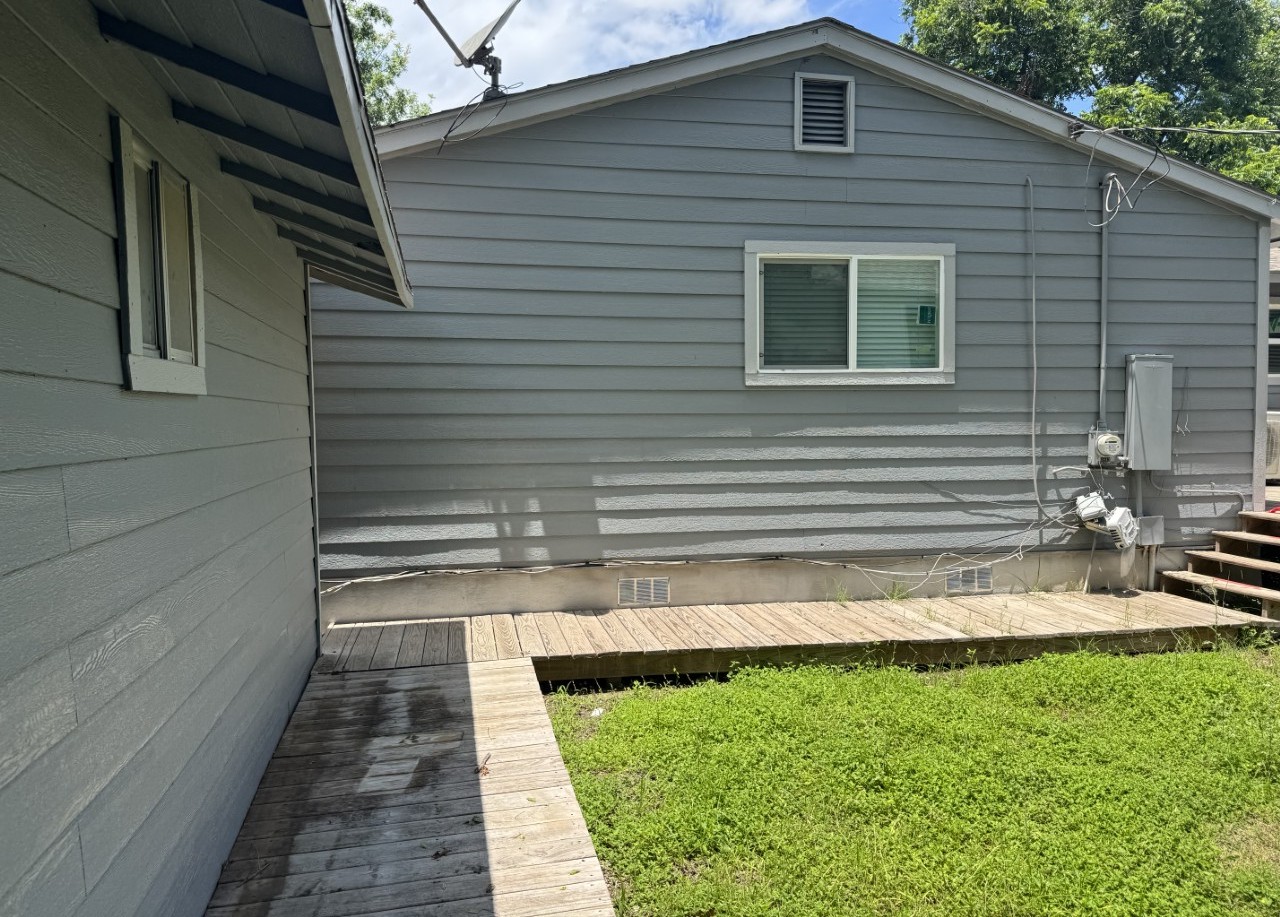 1813 Rhodes Road Austin, TX 78721 - Photo 13 of 14 A well-maintained side exterior boasts durable siding and a practical wooden walkway.