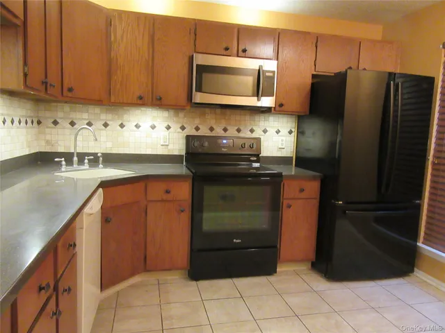a kitchen with granite countertop a refrigerator and a stove