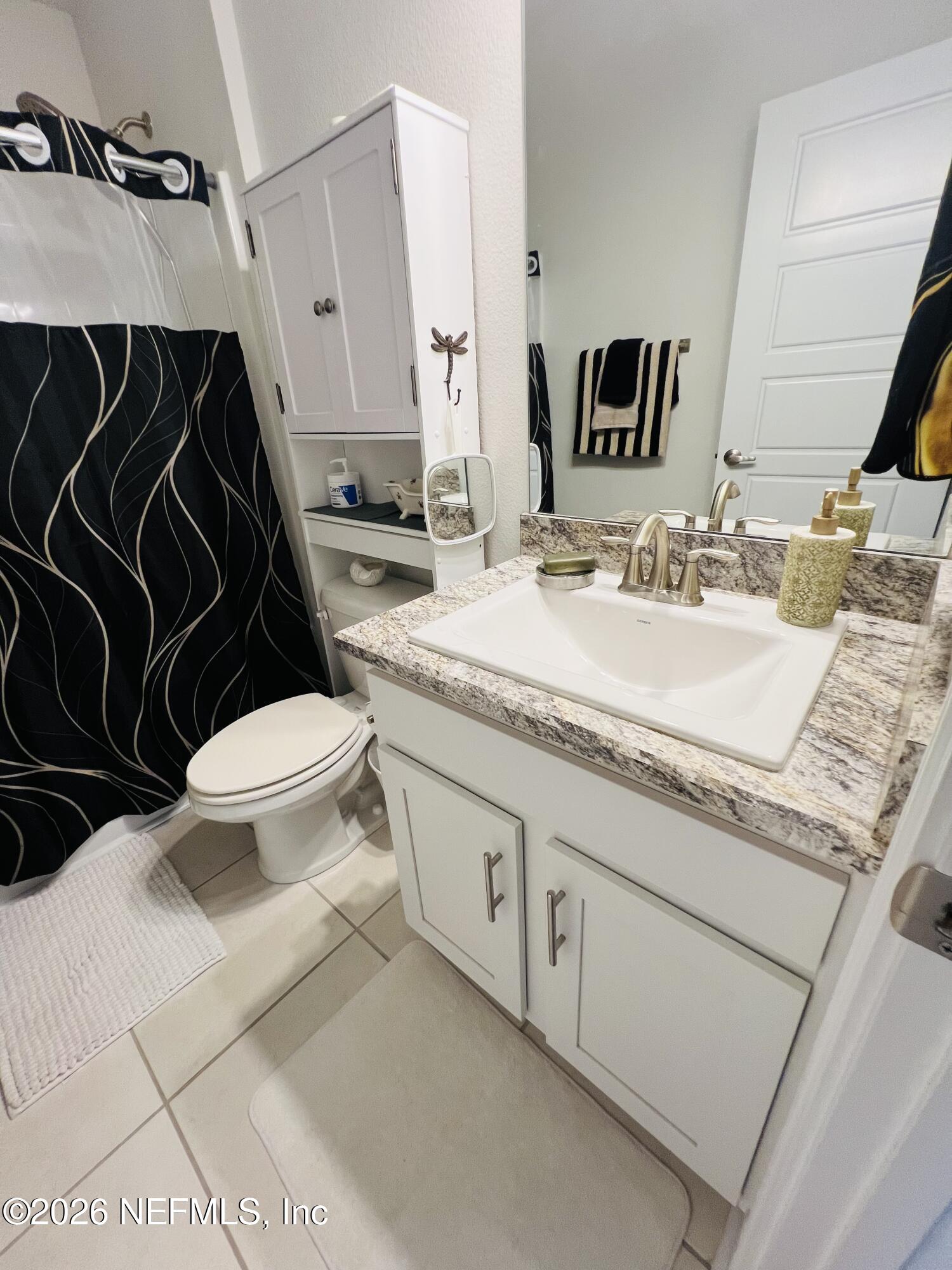 2 Rivertown Road Palm Coast, FL 32137 - Photo 59 of 80 a bathroom with a granite countertop toilet sink and mirror